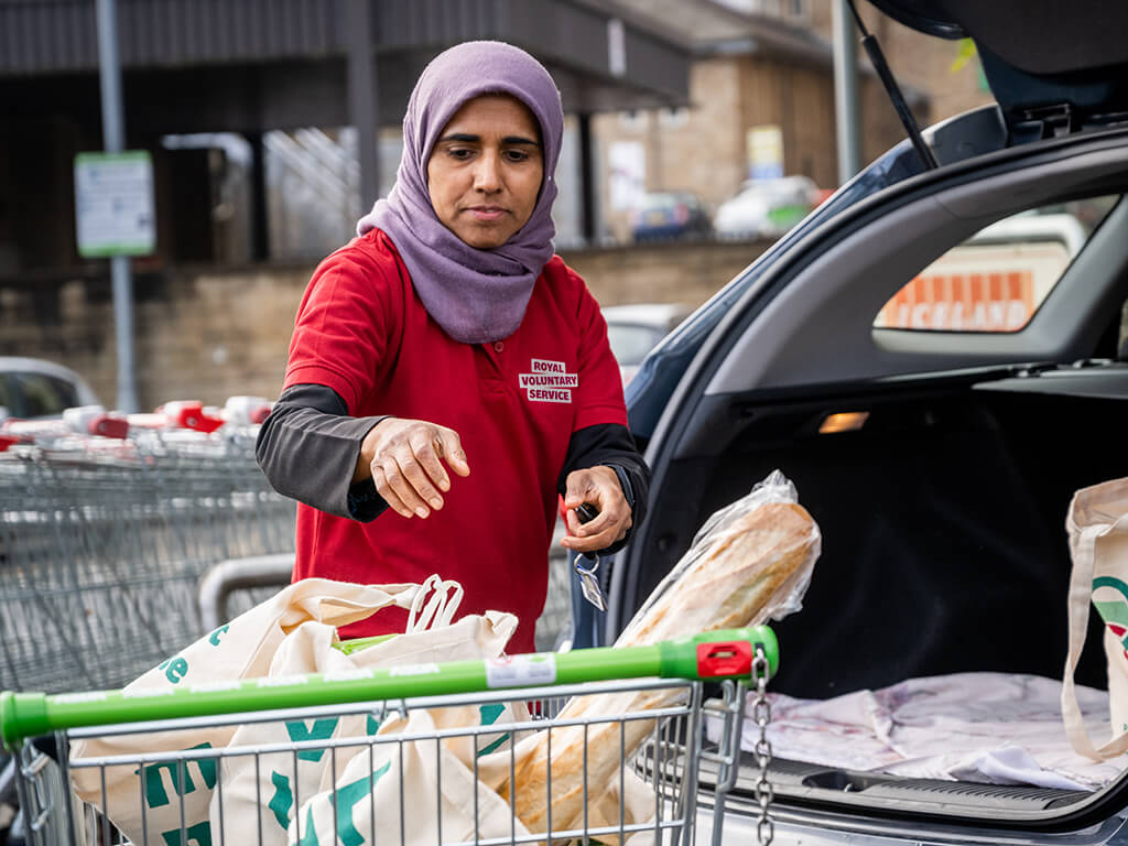 A Royal Voluntary Service volunteer lading her car with shopping for a client 