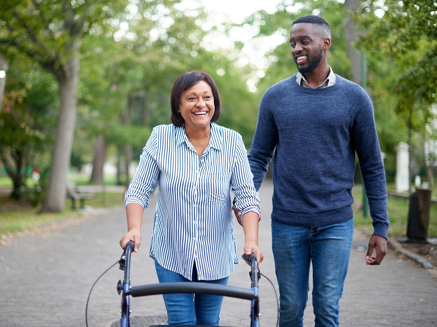 A male volunteer supporting a woman on a walk