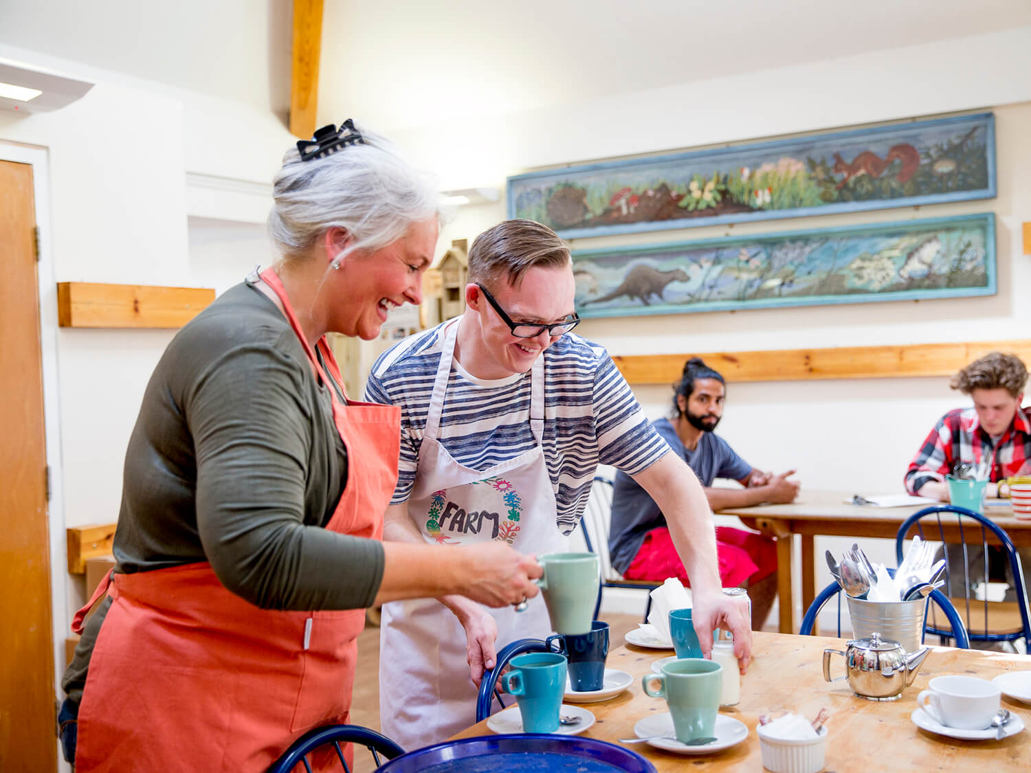 Two volunteers working at a cafe 