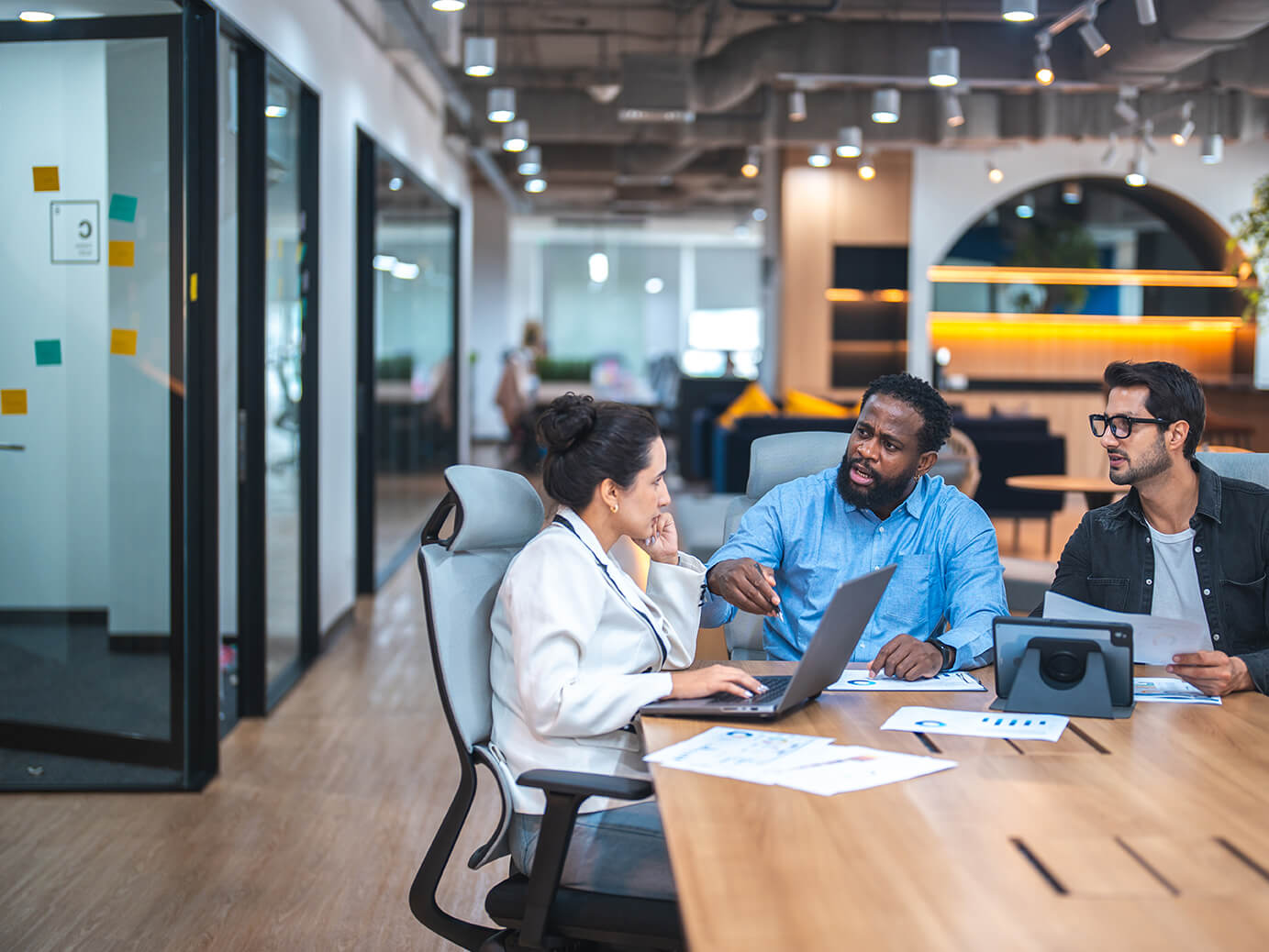 A group of profesionals in discussion in an open plan office 